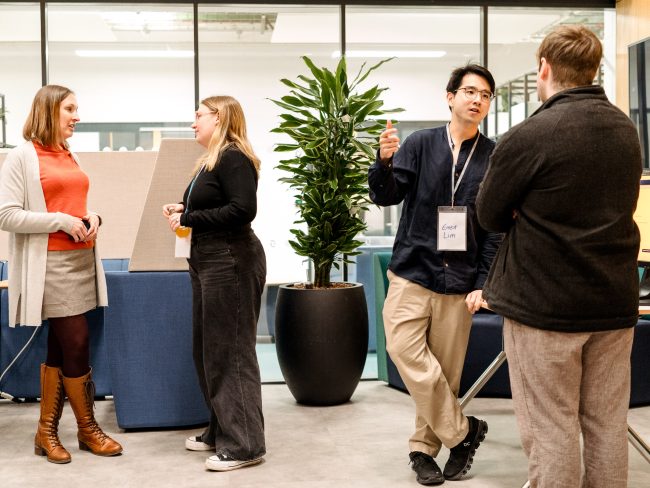 People chatting in the atrium for the Institute for Safe Autonomy.